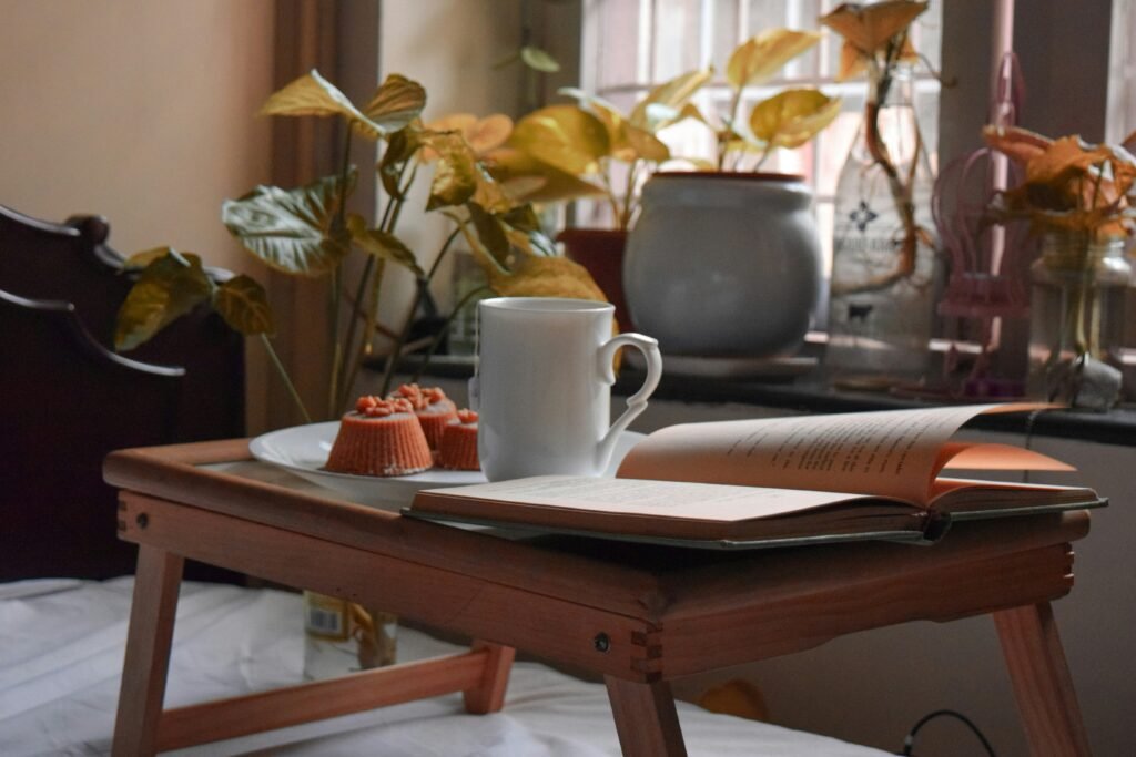 a coffee cup on the table and cake and book the inside green  plant  Beautiful Coffee Table Styling Tips